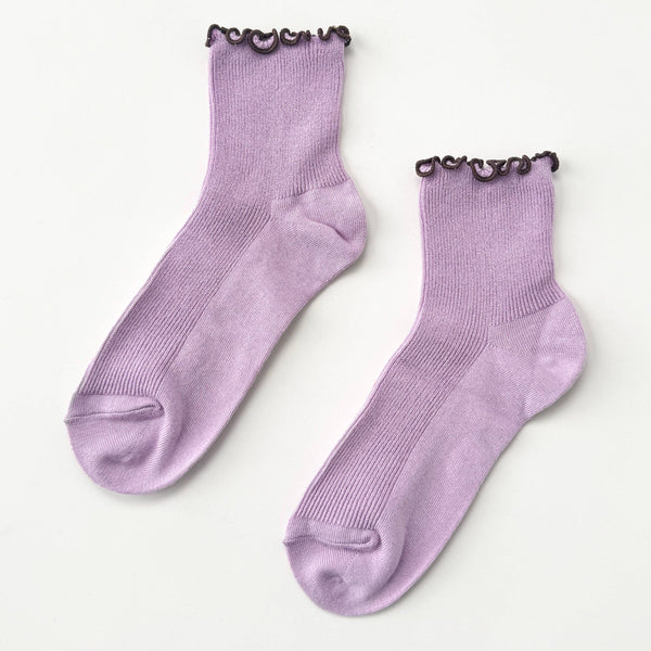 Pair of purple socks with brown ruffle trim on a white background