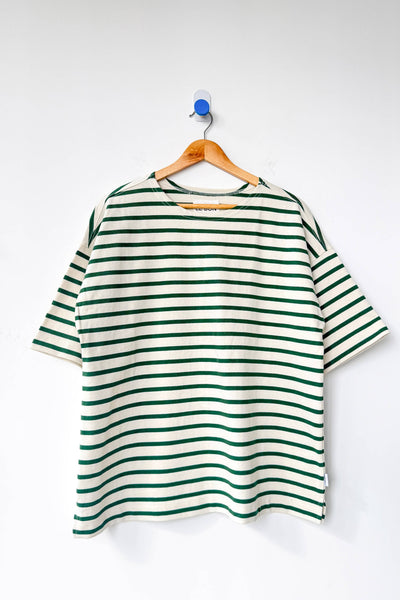 Green and white striped shirt on a hanger against a white background