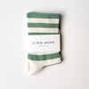 Green and white striped socks with 'Le Bon Shoppe' packaging on a white background