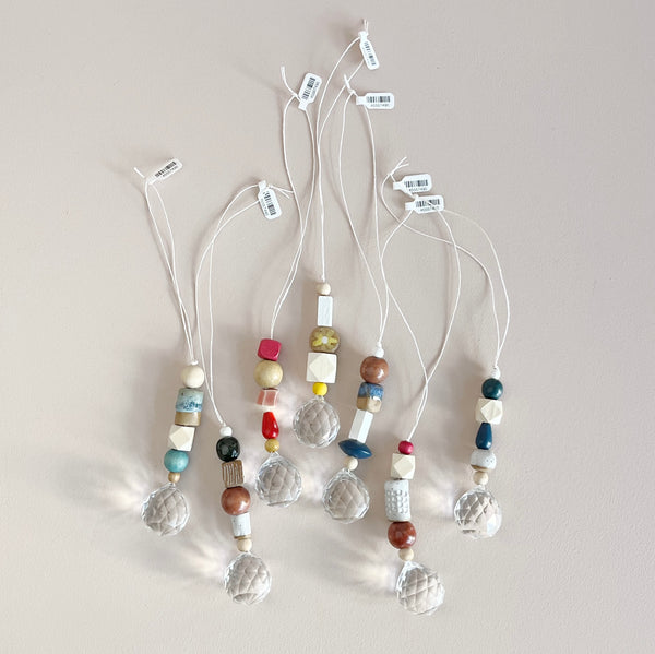 A group of ceramic and wood bead crystal ball suncatchers in a variety of colors and styles. 
