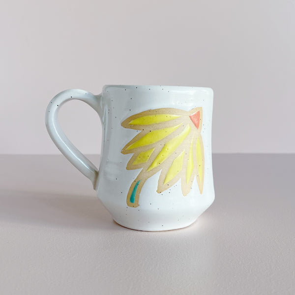 White ceramic mug with yellow coneflower design. 
