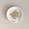 Ceramic spoon rest with pink coneflower design.