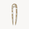 Iridescent beige hair pin on a white background