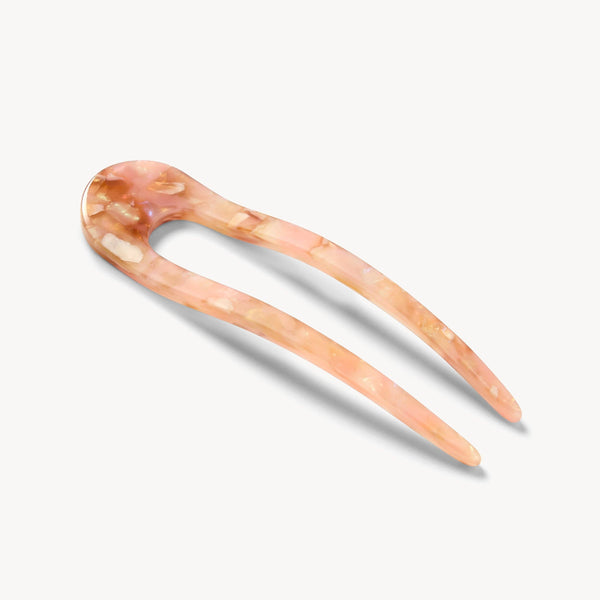 Marbled pink and beige hairpin on a white background