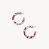 Pair of purple marbled hoop earrings on a white background.