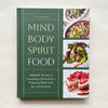 'Mind Body Spirit Food' cookbook cover on a beige background.