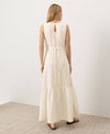 Woman wearing a long cream keyhole back dress against a white background