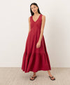 Woman wearing a red gauze cotton sleeveless dress against a white background