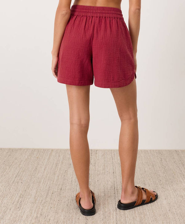 Person wearing red shorts on a neutral background