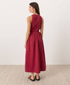 Woman wearing a red sleeveless midi dress standing against a white background