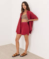 Woman wearing a red outfit with a beige background