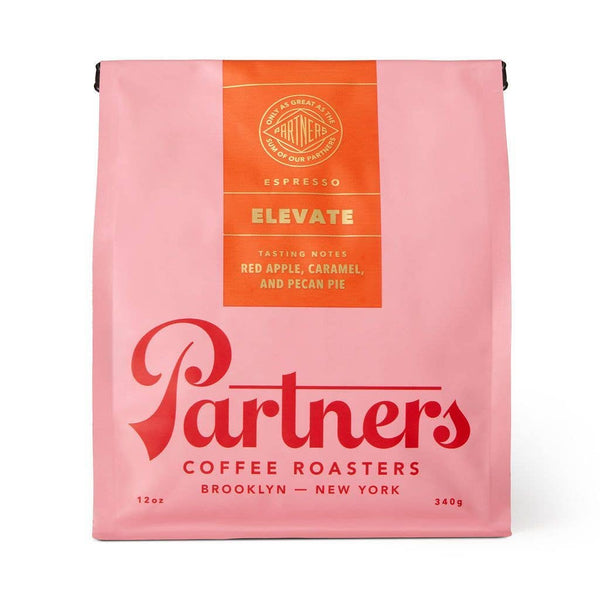 Pink coffee bag with orange 'elevate' label featuring 'Partners Coffee Roasters' branding on a white background