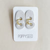 Textured white clay earrings with gold accents on a Poppyseed branded card against a beige background