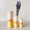 Three peach-orange gradient vases with lavender on a light gray background