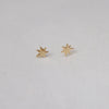 Yellow bronze star-shaped earrings on a light gray background