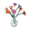 Colorful paper flowers in a clear glass vase on a white background
