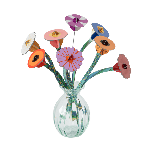 Colorful paper flowers in a clear glass vase on a white background
