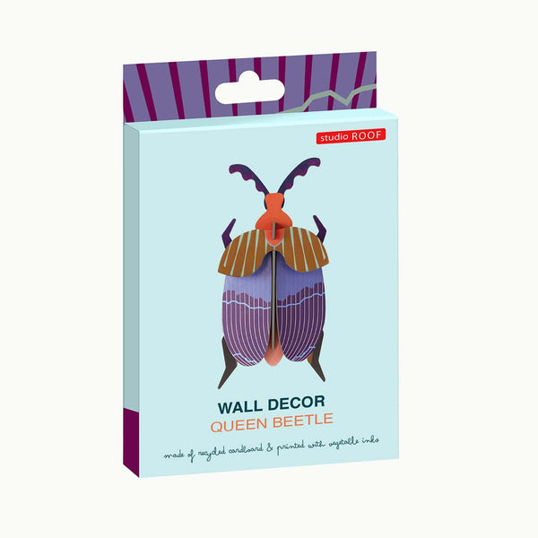 Packaged wall decor of a queen beetle on a light blue background