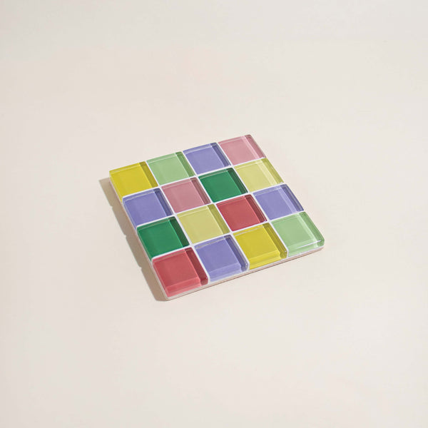 Colorful checkered coaster on a beige background