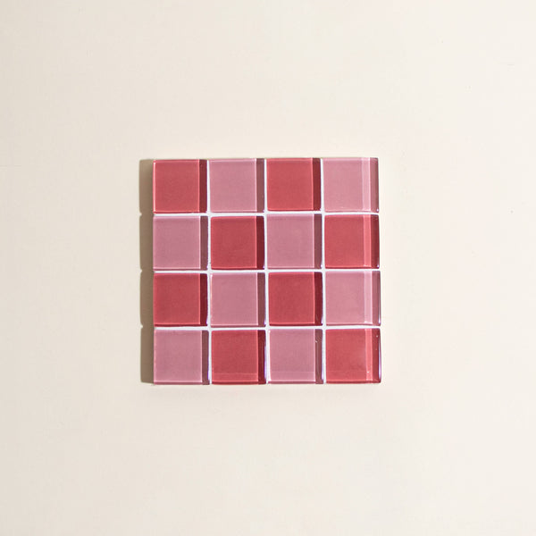 Rectangular glass tile with red and pink checkered pattern on a beige background