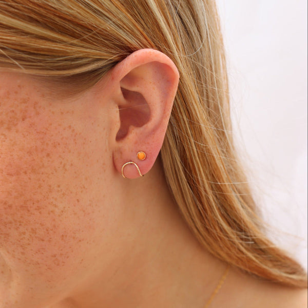 Close-up of person wearing a gold earring.