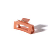 Coral-colored hair clip on a white background