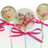Clear lollipops with colorful heart design and pink ribbons on a white background