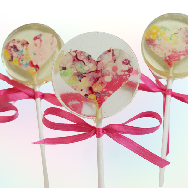 Clear lollipops with colorful heart design and pink ribbons on a white background