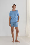 Person wearing a blue t-shirt and shorts set on a white background
