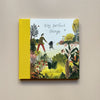 An illustrated children's book called 'Tiny, Perfect Things' with a cover design showing a parent and child walking through a bountiful nature area. The book sits against a neutral backdrop.