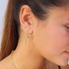 Close-up of a woman wearing a bow-shaped earring with a blurred background