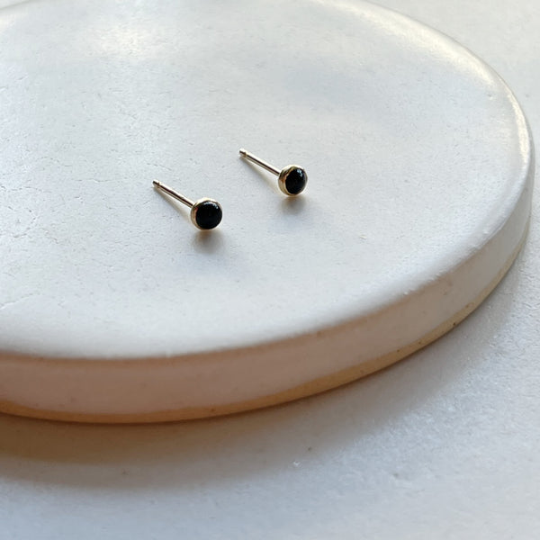 Pair of black onyx stud earrings on a white background.
