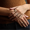 Close-up of hands with rings against a blurred background
