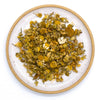 Chamomile loose leaf tea on a white plate.