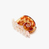Tortoiseshell hair clip in a sea snail design on a white background