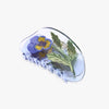 Violet pansy design set into translucent purple hair claw on a white background.