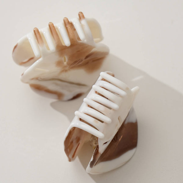 Marble-patterned hair claws on a light background