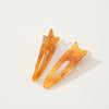 Two orange tortoiseshell cat-shaped hair barrette clips on a white background