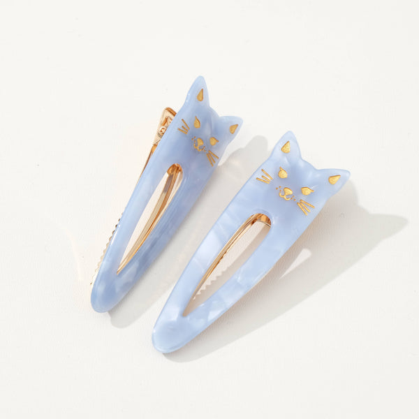 Two light blue cat-shaped hair clips with gold accents on a white background