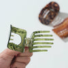 A hand holds open a translucent olive green claw hair clip in the foreground, with two blurred tortoiseshell-style claw hair clips in the background on a clean white surface.