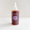 A bottle of Shiitake Mushroom Oil with a white cap on a light background.