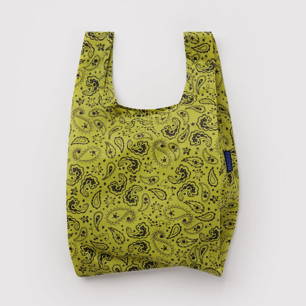 A small nylon shopping back in chartreuse with black paisley print on a white backdrop.