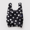 A small nylon shopping bag in black with silver metallic polka dots against a white backdrop.