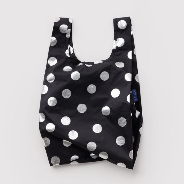 A small nylon shopping bag in black with silver metallic polka dots against a white backdrop.