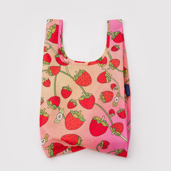 A small nylon shopping bag in a gradient orange and pink with strawberry blossom print on a white backdrop.