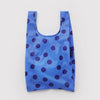 Blue reusable tote bag with purple polka dots on a light gray background
