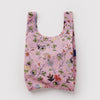Reusable pink shopping bag with floral and animal pattern on a light gray background
