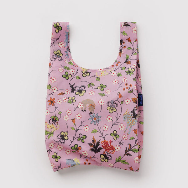 Reusable pink shopping bag with floral and animal pattern on a light gray background