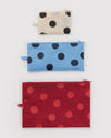 Three polka dot pouches in off-white & black, blue, and red on a white background