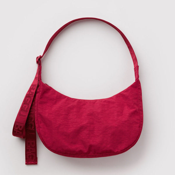 Bold red nylon crescent crossbody bag on a white background.